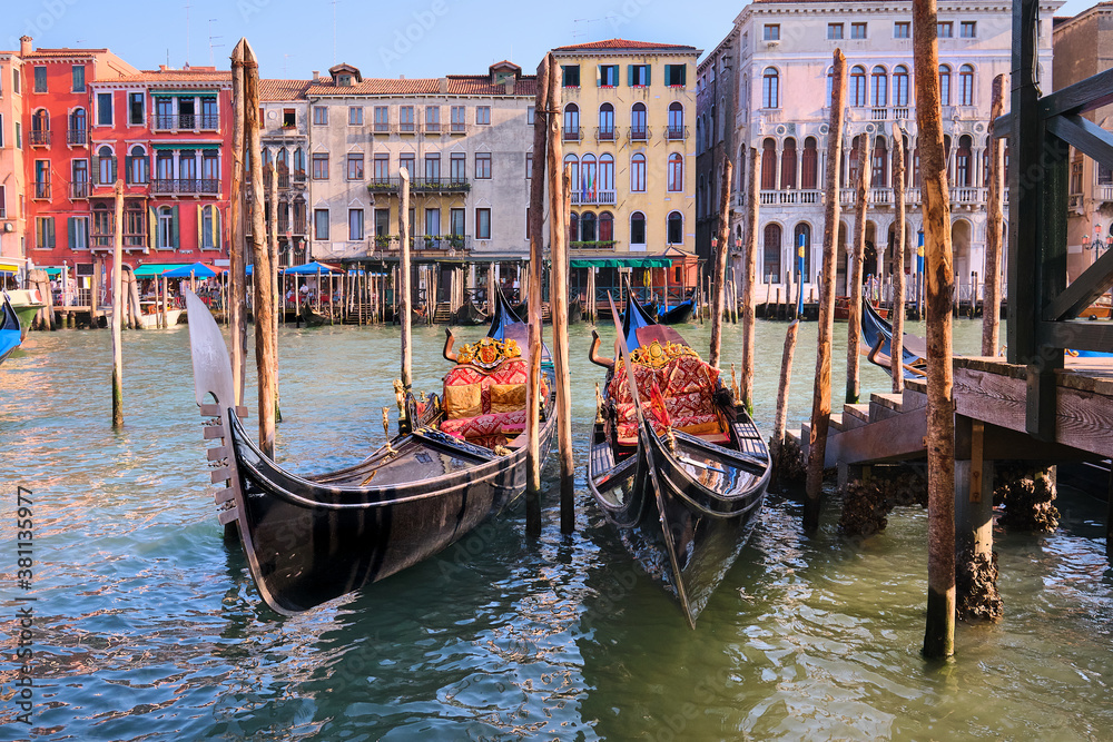 Gondolas moored by the pier on Grand Canal in Venice, Italy.