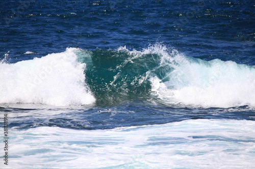 Big breaking ocean wave on a sandy beach
