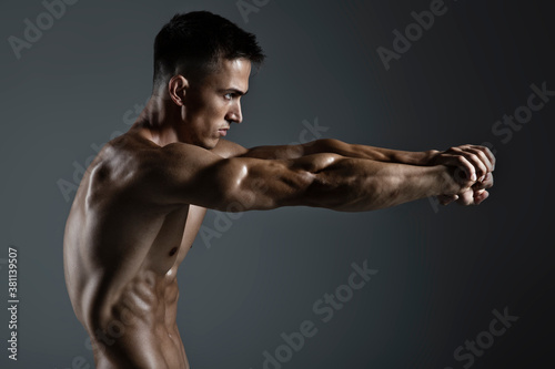 Portrait of handsome young man with stylish haircut posing over gray background. Perfect body & skin. Close up. Studio shot