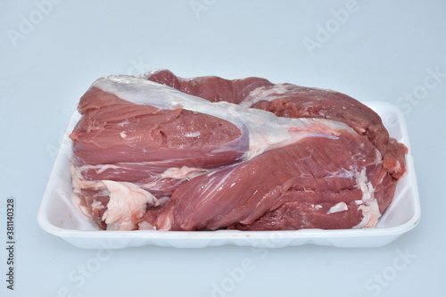 fresh organic boneless raw meat closeup,a part of lamb body isolated in plate on white background