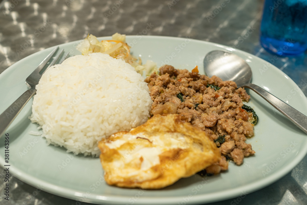 Thai local food, gapao rice, rice served with minced chicken or pork, comes with fried egg.