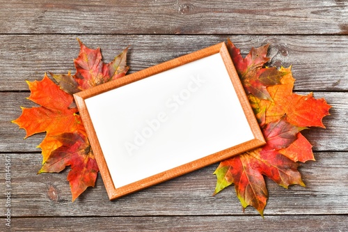 Teacher's Day. Autumn composition. Empty frame for an inscription and red maple leaves. Copy space. Top view, flat lay. Autumn concept. Greeting Card. Thanksgiving day.