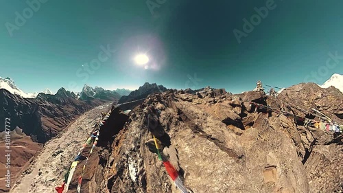 Gokyo Ri mountain top. Tibetan prayer Buddhist flag. Wild Himalayas high altitude nature and mount valley. Rocky slopes covered with ice. Tiny planet transformation