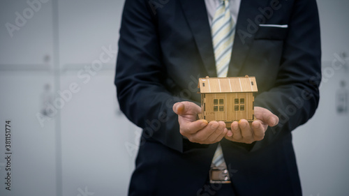 Φωτογραφία Man in Black holds their dream home, real estate and home insurance concept