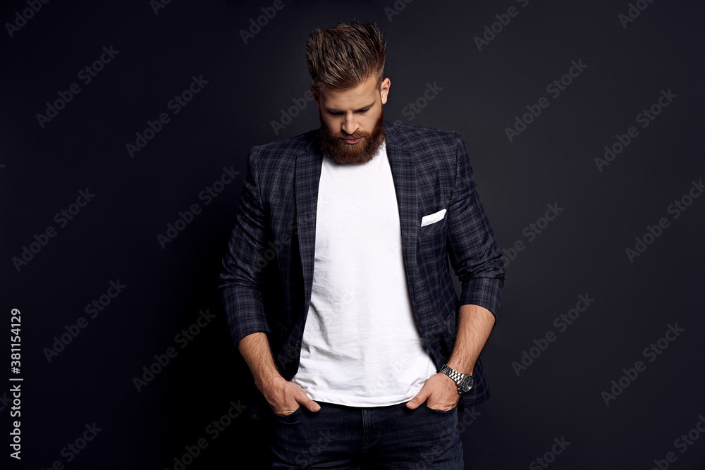 Thinking about something. Upset man with long hair and beard standing against grey background
