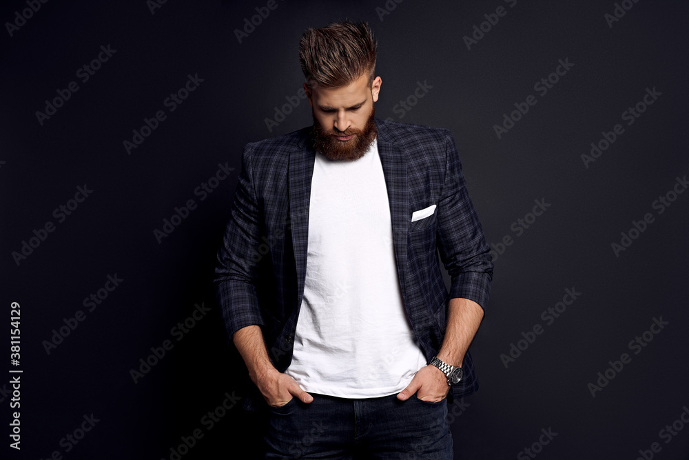 Thinking about something. Upset man with long hair and beard standing against grey background Thinking about something. Upset man with long hair and beard standing against grey background
