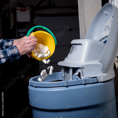 Canvas-taulu Homeowner adds salt to a water softener