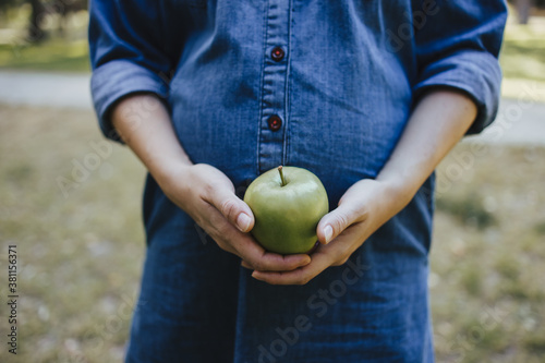 Canvas-taulu Pregnant woman snacking healthy with green apple