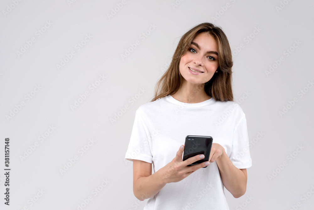 Woman wearing a white shirt using a mobile phone isolated on a white background Woman wearing a white shirt using a mobile phone isolated on a white background