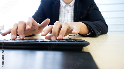 Close up hand of businessman support customer and answer the question as a call center by typing solution on computer keyboard in workplace at company office