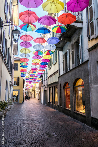 central street of Arona with many colored umbrellas hanging