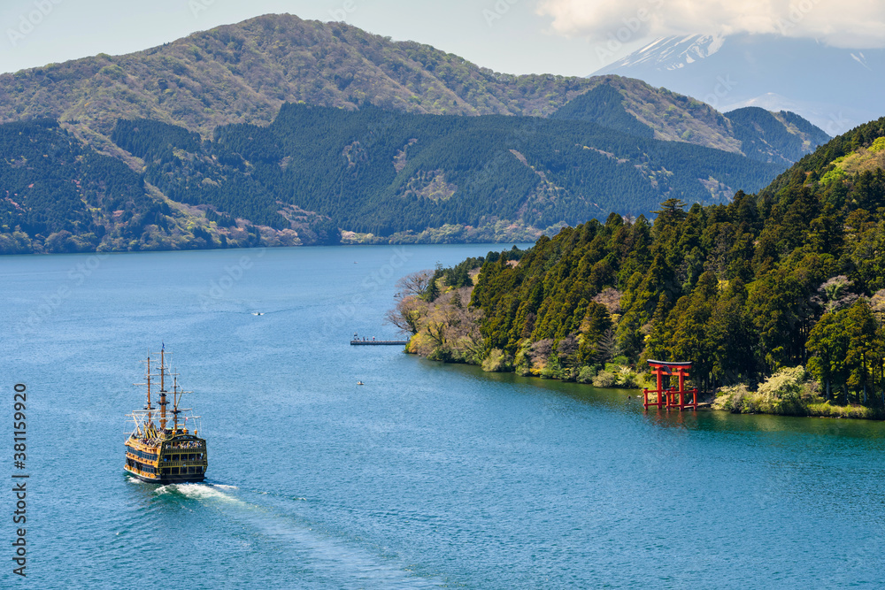 Red torii gate and tourist cruise at Lake Ashi, Hakone
