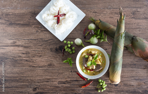 Chicken green curry with bamboo shoots and blood pudding (Kaeng kheiyw hwan) on dark wooden background with Thai tradition food served with steamed rice. Thai food very popular photo