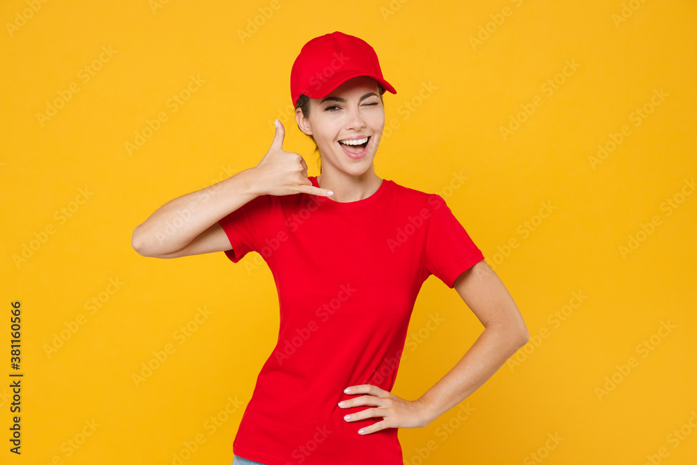 Delivery employee woman in red cap blank t-shirt uniform workwear work courier in service during quarantine coronavirus covid-19, doing phone gesture, says call me back isolated on yellow background. Delivery employee woman in red cap blank t-shirt uniform workwear work courier in service during quarantine coronavirus covid-19, doing phone gesture, says call me back isolated on yellow background.