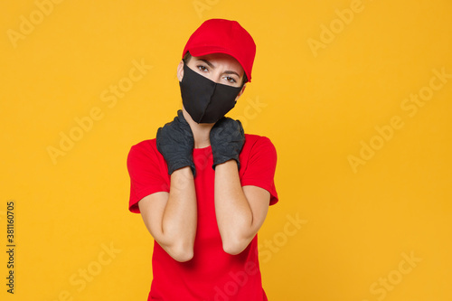 Delivery employee woman in red cap blank t-shirt uniform protect face mask gloves working courier in service during quarantine coronavirus covid-19 virus isolated on yellow background studio portrait.