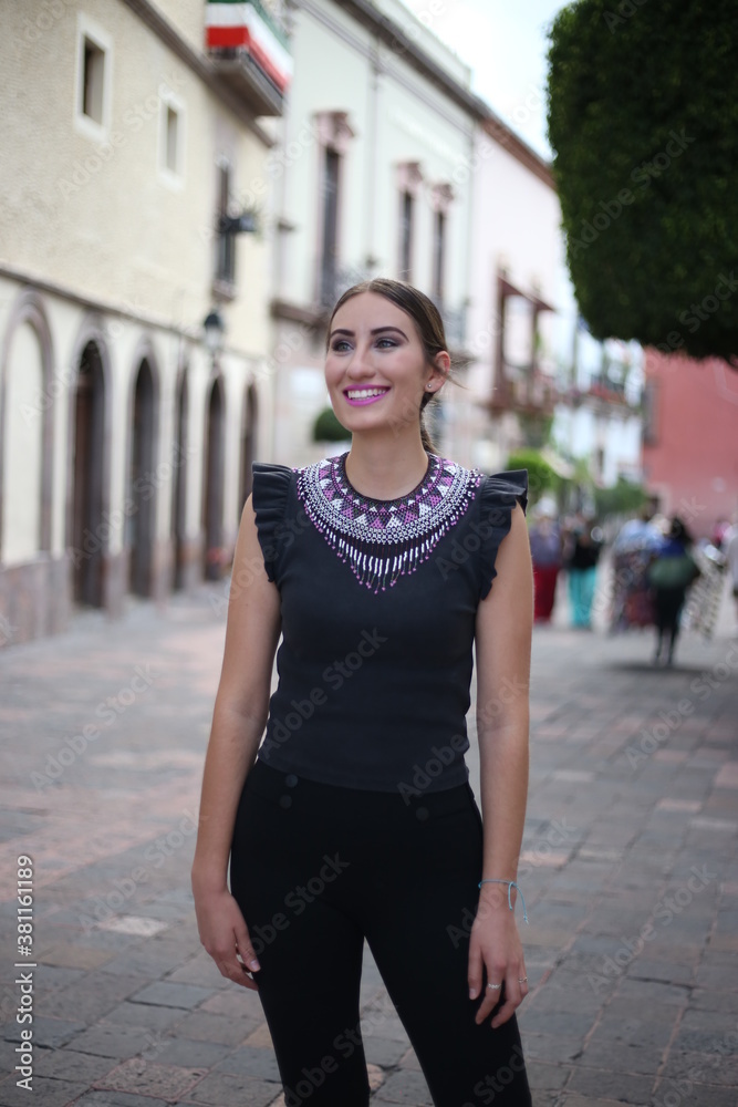 Portraits of a charming red-haired girl with a cute face. Girl posing for the camera in the city center. She has a wonderful mood and a lovely smile, mexican lifestyle, mexican concept queretaro Portraits of a charming red-haired girl with a cute face. Girl posing for the camera in the city center. She has a wonderful mood and a lovely smile, mexican lifestyle, mexican concept queretaro
