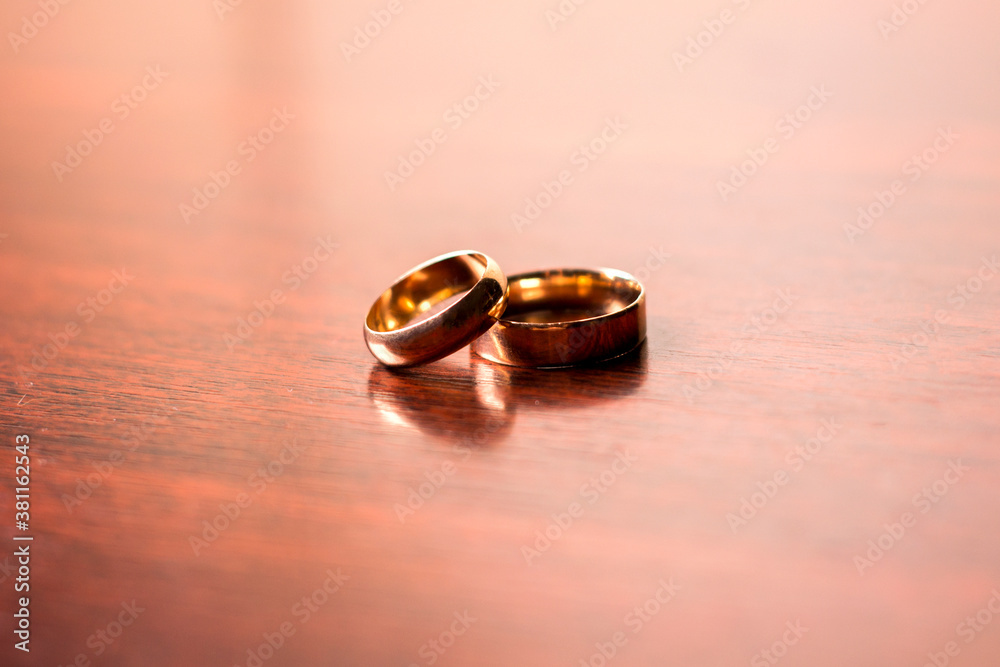 Gold wedding rings on a wooden background.Wedding attributes. Wedding ceremony Gold wedding rings on a wooden background.Wedding attributes. Wedding ceremony