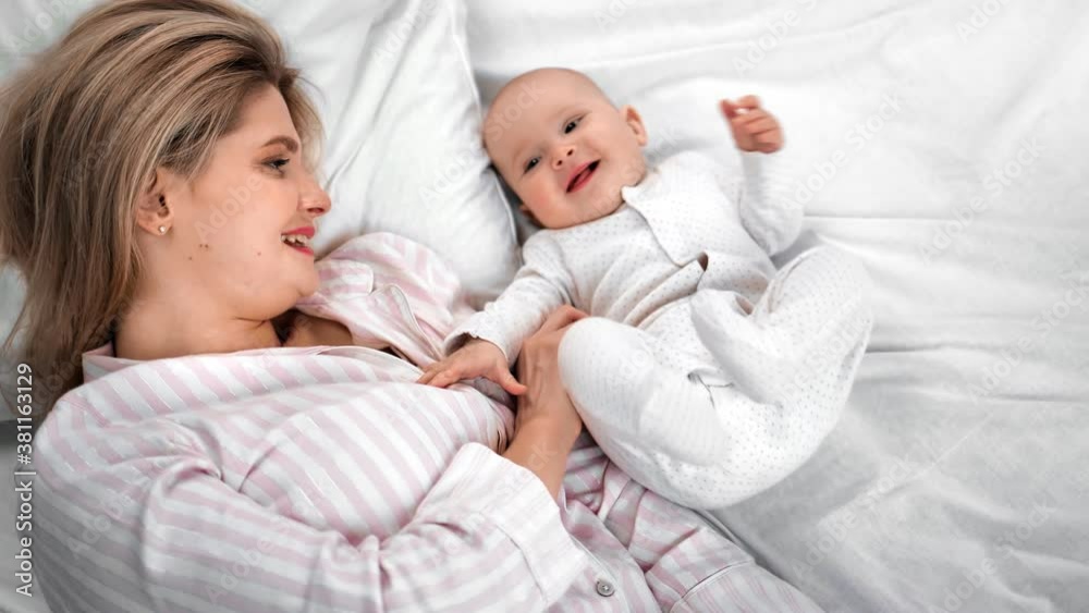 Happy family mother and cute little baby enjoying morning lying on bed. 4k Dragon RED camera Happy family mother and cute little baby enjoying morning lying on bed. 4k Dragon RED camera