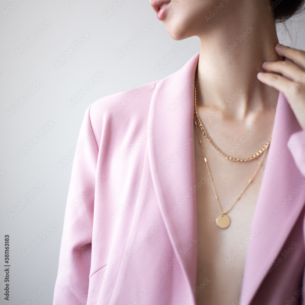 Closeup photo of young woman wearing pink jacket and golden necklace - obrazy, fototapety, plakaty 