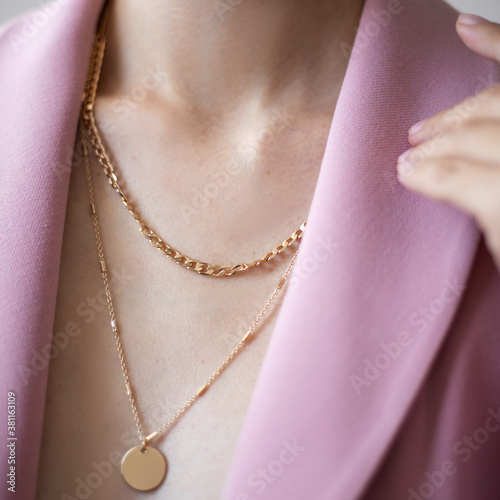 Fototapeta Closeup photo of young woman wearing pink jacket and golden necklace