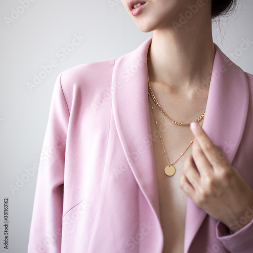 Obraz na plátně Closeup photo of young woman wearing pink jacket and golden necklace