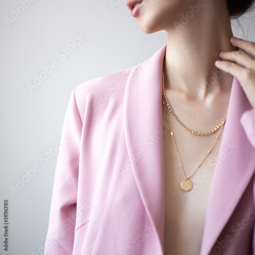 Murais de parede Closeup photo of young woman wearing pink jacket and golden necklace