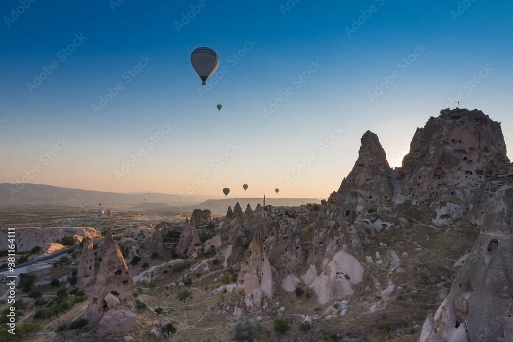 Uchisar castle and town, hot air balloons in sunrise, Cappadocia, Turkey