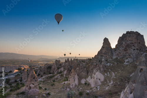 Uchisar castle and town, hot air balloons in sunrise, Cappadocia, Turkey