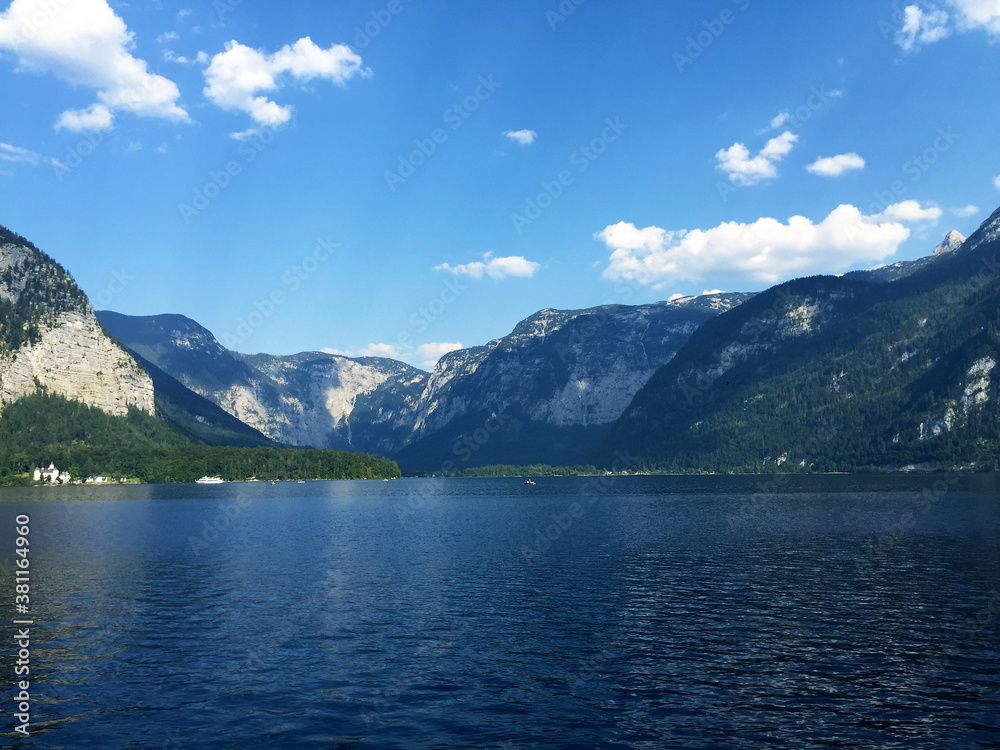 landscape of lake and mountains against blue sky at sunny day in Hallstatt Upper Austria landscape of lake and mountains against blue sky at sunny day in Hallstatt Upper Austria