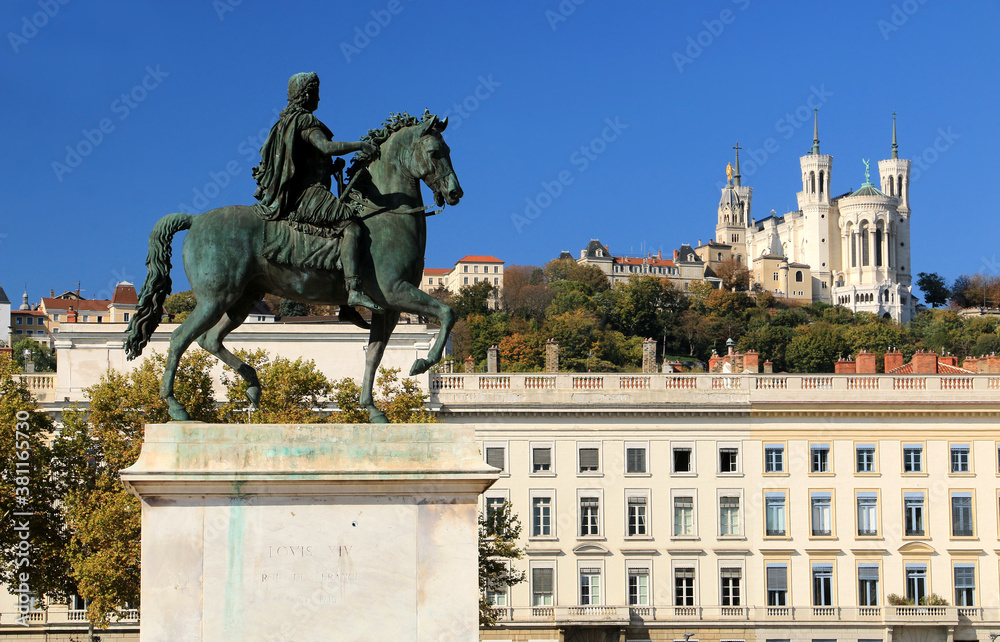 La statue de Louis IX sur  la place Bellecour à Lyon et la basilique de Fourvière en arrière plan.