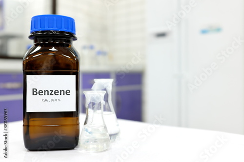 Selective focus of benzene liquid chemical compound in dark glass bottle inside a chemistry laboratory with copy space. Aromatic hydrocarbon used in petrochemical industry.	 photo