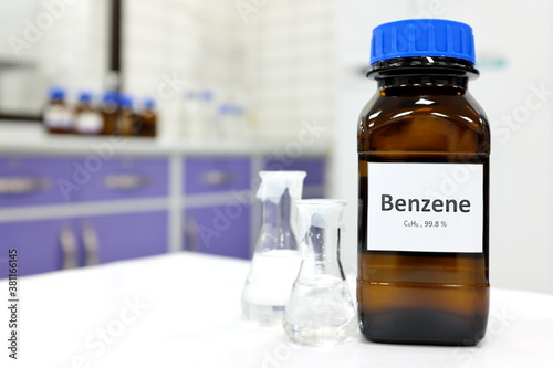 Selective focus of benzene liquid chemical compound in dark glass bottle inside a chemistry laboratory with copy space. Aromatic hydrocarbon used in petrochemical industry.	 photo