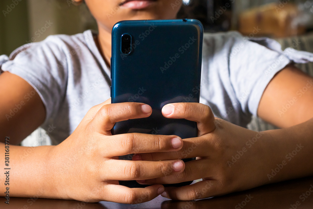 Manos de una niña sujetando un celular Manos de una niña sujetando un celular
