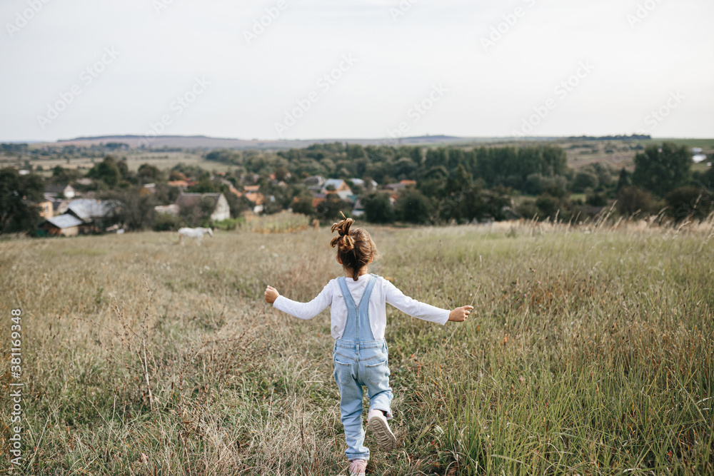 little girl runs through a meadow in the mountains. little girl runs through a meadow in the mountains.
