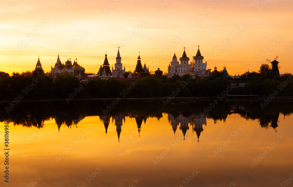 Awe orange sunset over blurry reflection of the Izmailovsky Kremlin in the lake water at Moscow, Russia. Russian landscape in warm colors