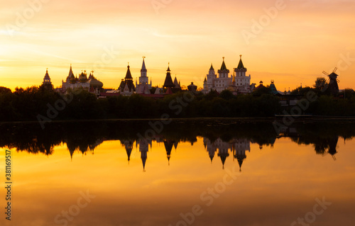 Awe orange sunset over blurry reflection of the Izmailovsky Kremlin in the lake water at Moscow, Russia. Russian landscape in warm colors © Вера Тихонова