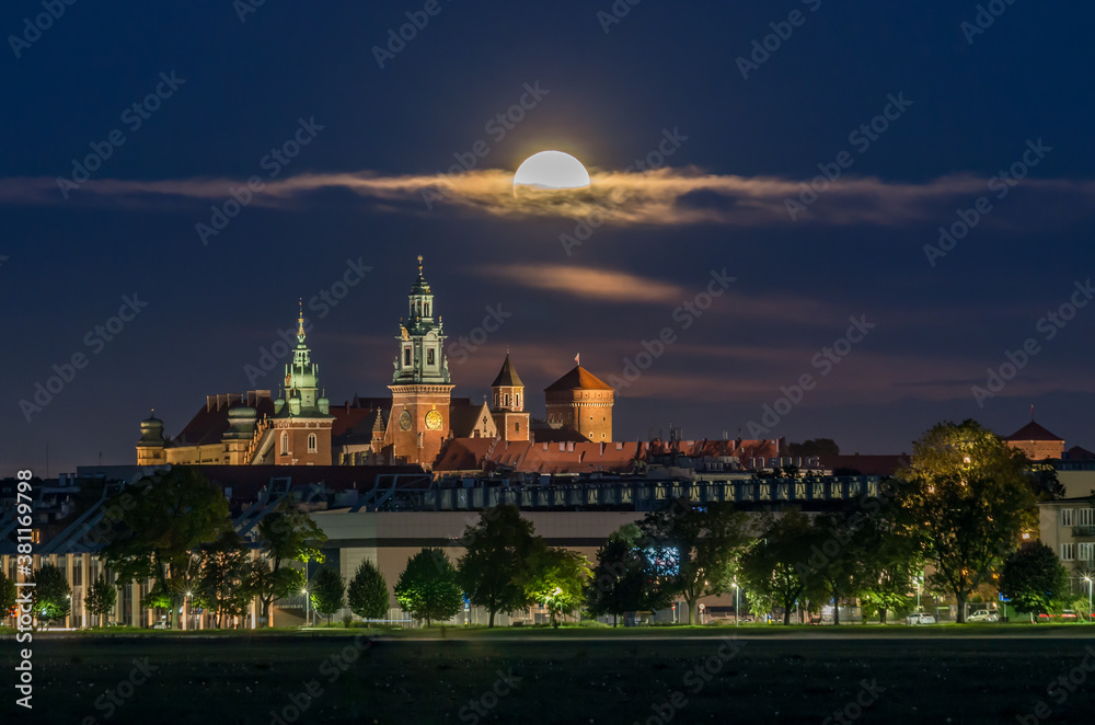 Wawel Castle and full moon, Krakow, Poland, seen from Blonia meadow.