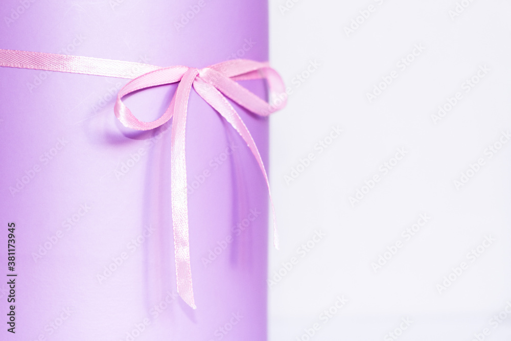 Festive purple box with a bow on the table. Content for congratulations. partial focus