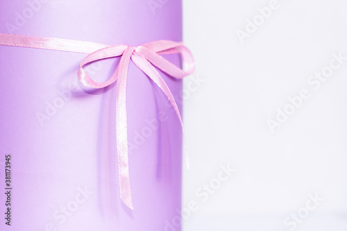 Festive purple box with a bow on the table. Content for congratulations. partial focus © PanArt