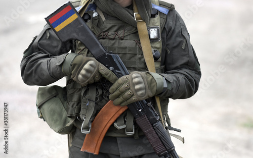 Flag of Armenia on submachine gun butt. Military Conflict in the Caucasus. Collage.