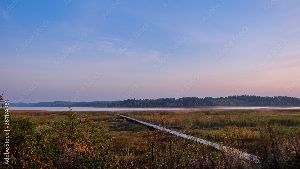 A long wooden pier to the lake trough reeds