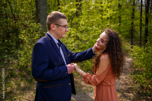 Beautiful couple in the woods. Girl with elegant haircut hugs her man in a suit. Rustic outdoors details photography portrait. Happy woman and boyfriend © Дмитрий Ткачук