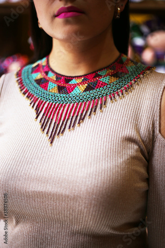 beautiful smiling mexican woman in traditional mexican dress hands up holding the skirt as a background like peacock, neckless , morena de fuego luces, papel picado, mexican doll photo