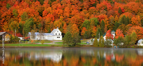 Fototapeta Naklejka Na Ścianę i Meble -  Panoramic view of old barn by the lake with fall foliage near Danville, Vermont

