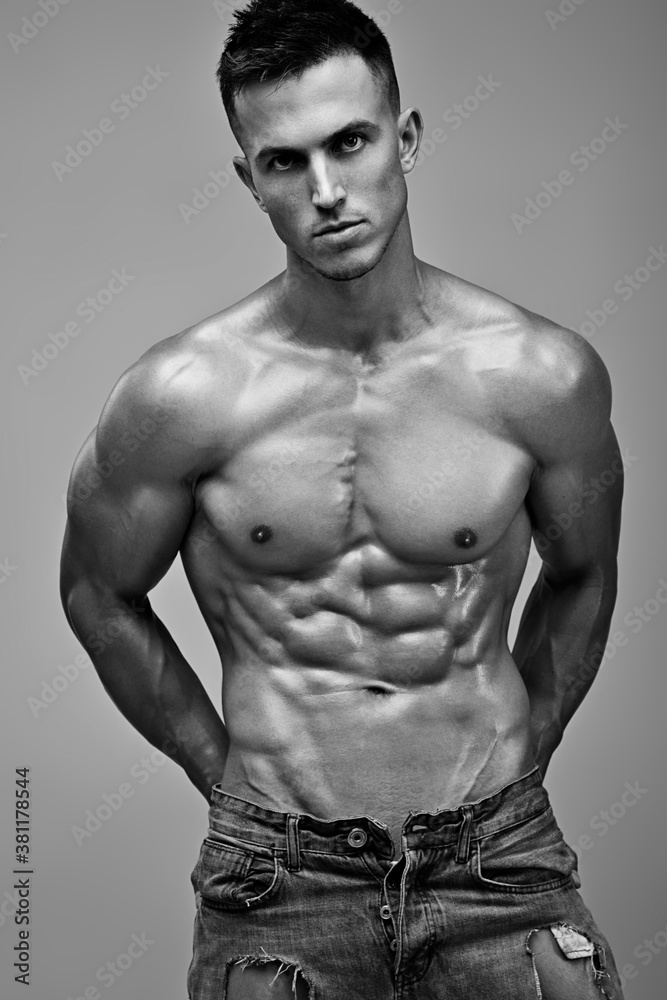 Male shirtless model with perfect body in jeans posing over gray ...