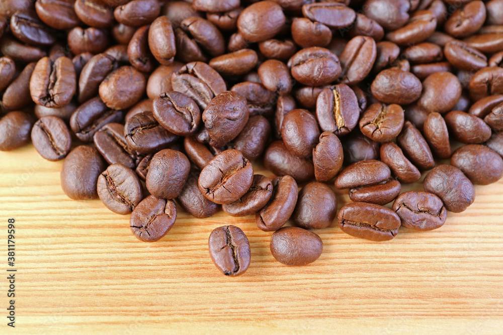Naklejka premium Heap of Roasted Coffee Beans on Wooden Background