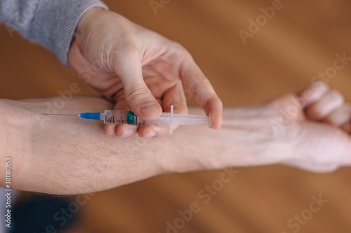 Drug addict hands holding syringe for injection