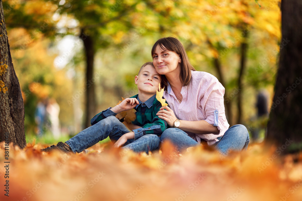 Mom and son are resting in a beautiful colorful autumn park. Love and tenderness. Soft focus. Mom and son are resting in a beautiful colorful autumn park. Love and tenderness. Soft focus.