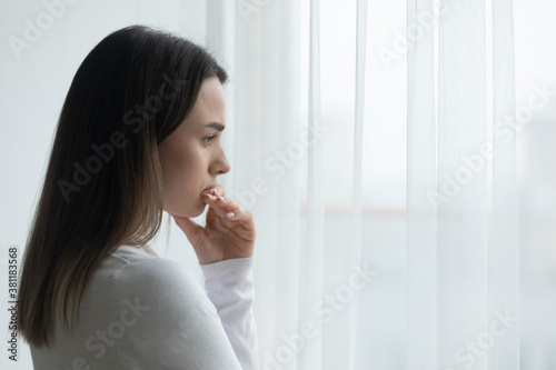 Pensive young Caucasian woman look in window distance thinking or pondering of life problems. Thoughtful millennial female lost in thoughts feel lonely lack communication. Loner, outcast concept.