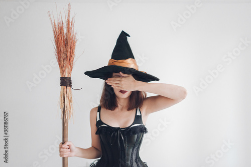 witch in corset and hat with broom - halloween costume